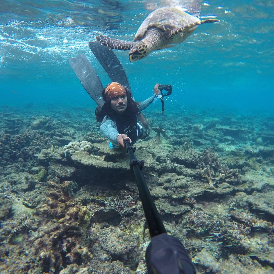 Moosa, guía local, buceando junto a una tortuga en Maldivas