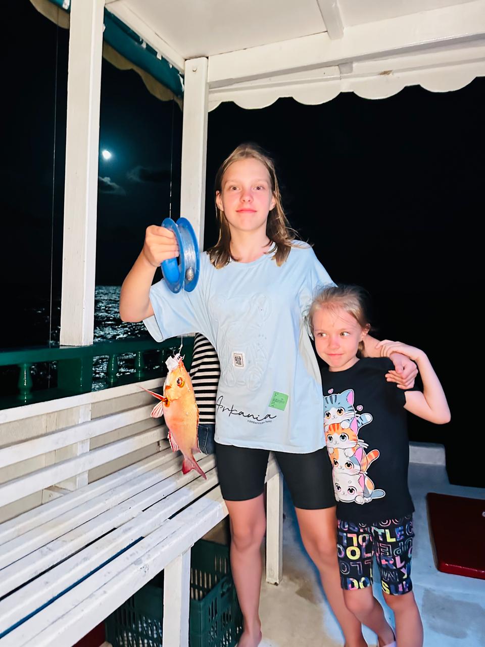 Niños mostrando su pesca durante una salida nocturna en Maldivas